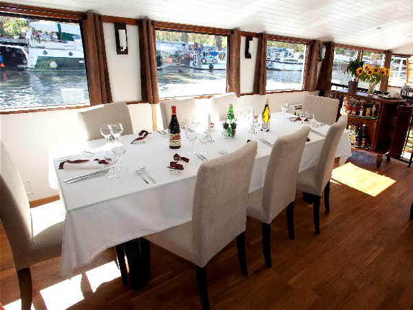 El luminoso comedor del "Enchanté" ofrece impresionantes vistas a traves de las cristaleras CRUCEROS FLUVIALES ENCHANTE CANALES DE FRANCIA CRUCEROS EN FAMILIA BARCOS PRIVADOS CRUCEROS BARCOS PEQUEÑOS CRUCEROS FLUVIALES DE LUJO CRUCEROS ALQUILER CHARTER FAMILIAS GRUPOS